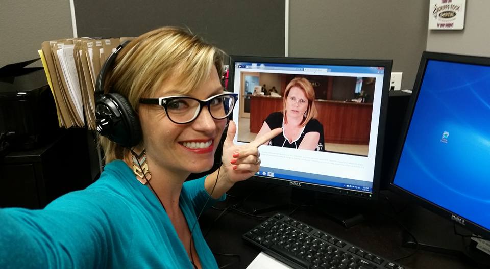 Front Office Rocks customer with headphones on pointing to a laptop screen with a Front Office Rocks training